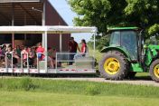 Big green tractor prepares to take the new 'People Hauler' on a farm tour